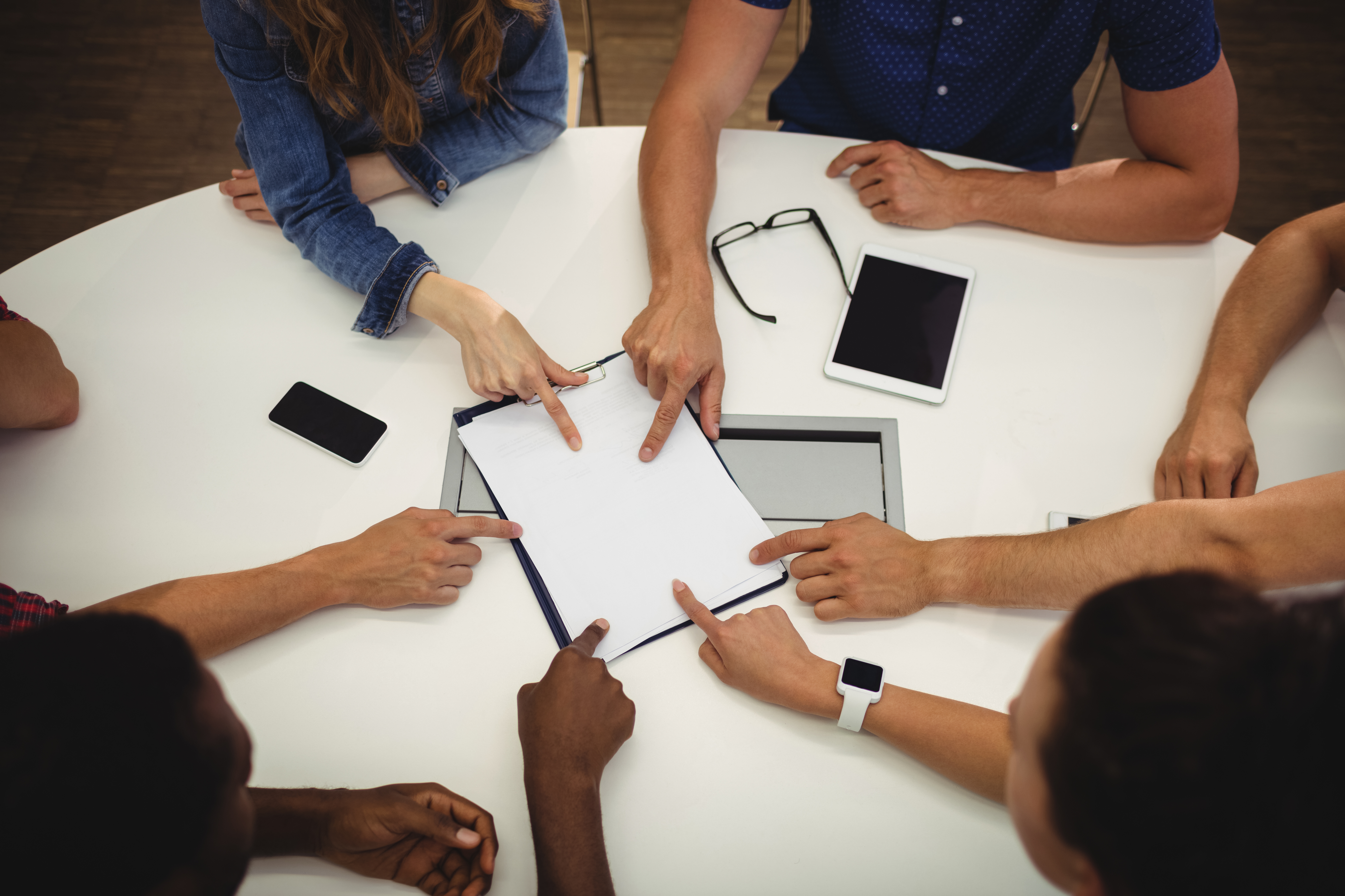Business executives pointing on clipboard in office